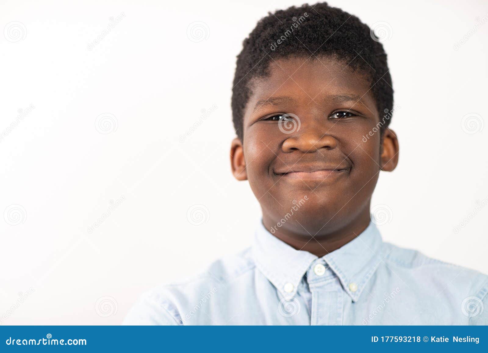 Head And Shoulders Studio Portrait Of Smiling Boy Against White