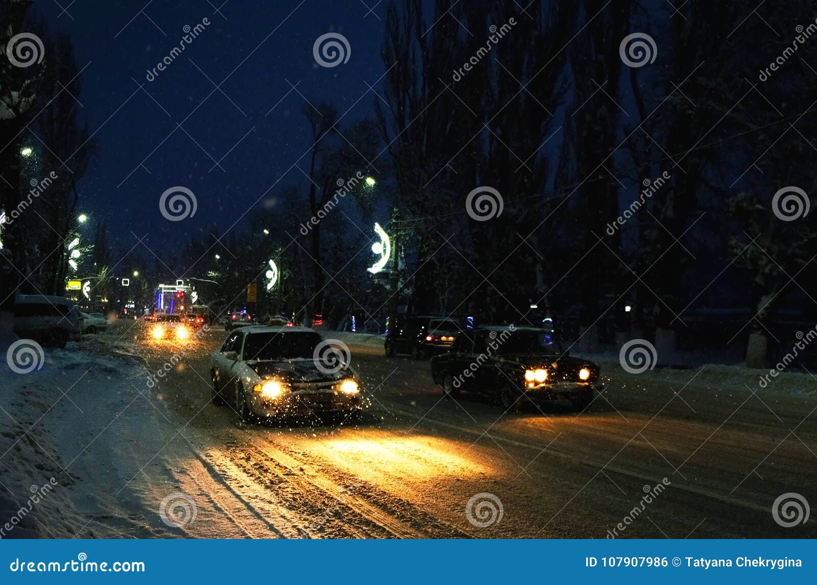 Headlights of Car in Snowfall on a Winter Night in a City Stock Photo