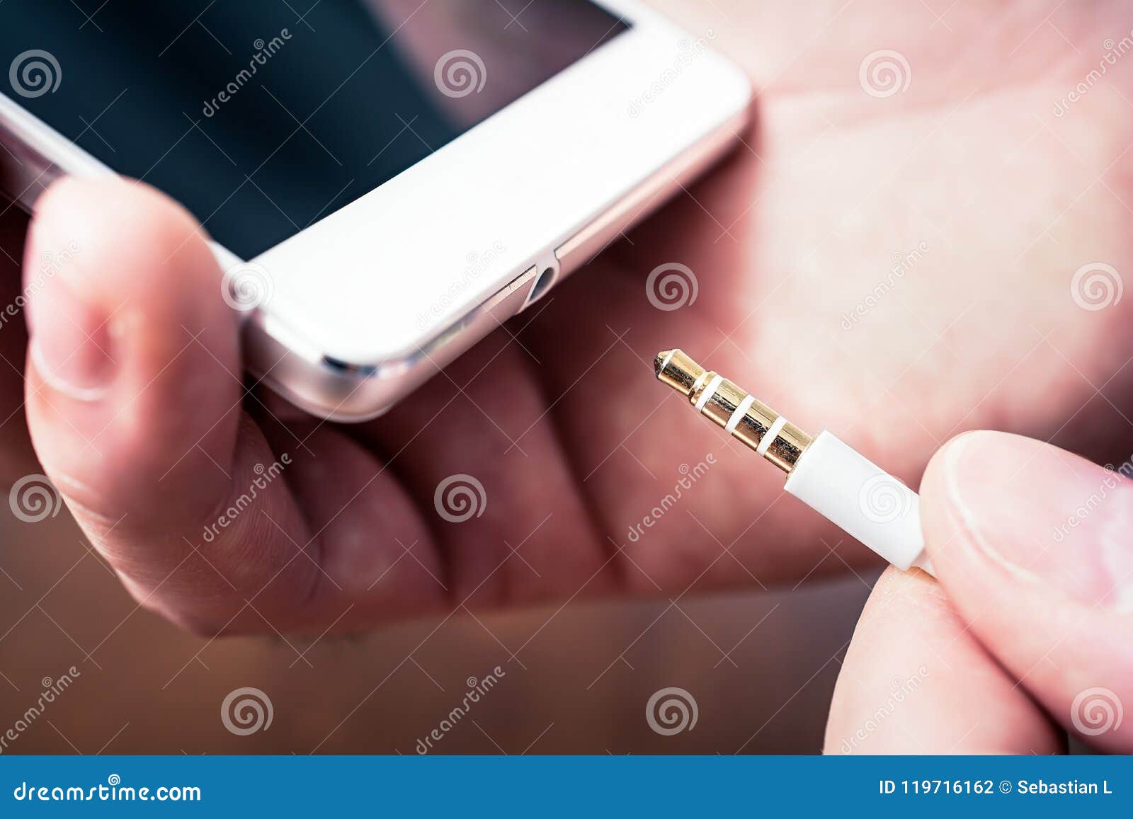 Headphone Jack of a White Smartphone Gets Plugged in a White Headset Cable Stock Photo Image