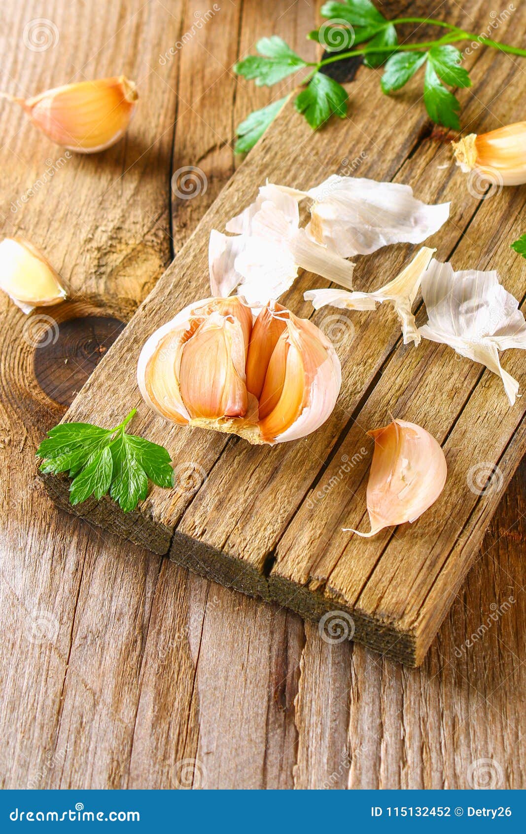 heads of garlic with parsley on a wooden table.
