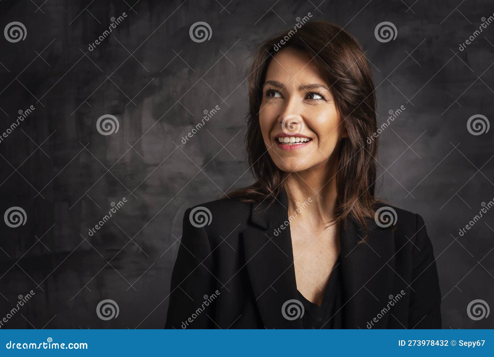 tudio portrait of beautiful brunette haired woman against  dark background