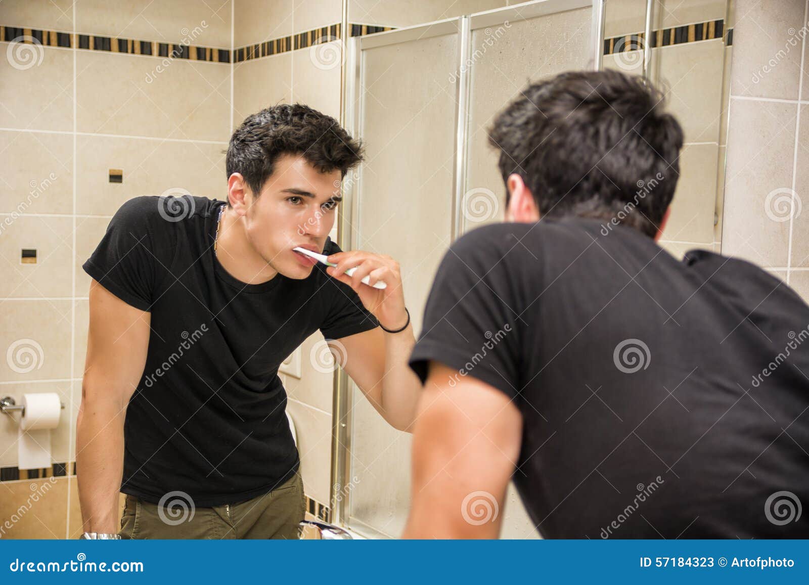 headshot of attractive young man brushing teeth
