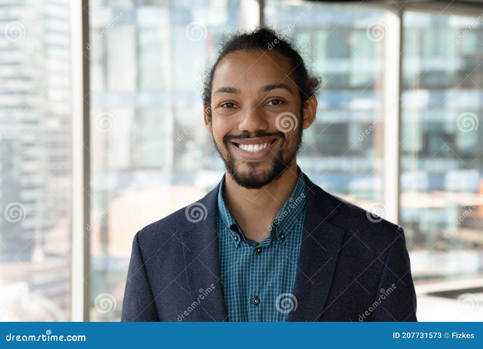 headshot portrait of smiling ethnic businessman in office