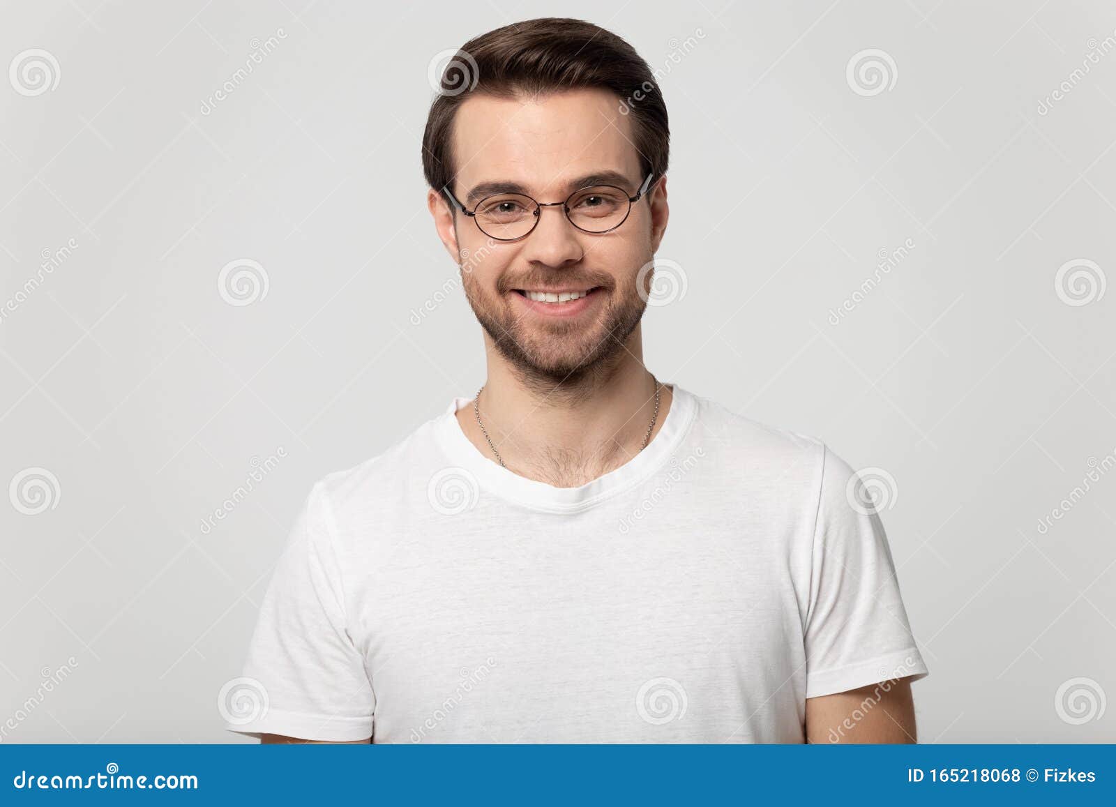 headshot portrait of smiling man in glasses on studio background