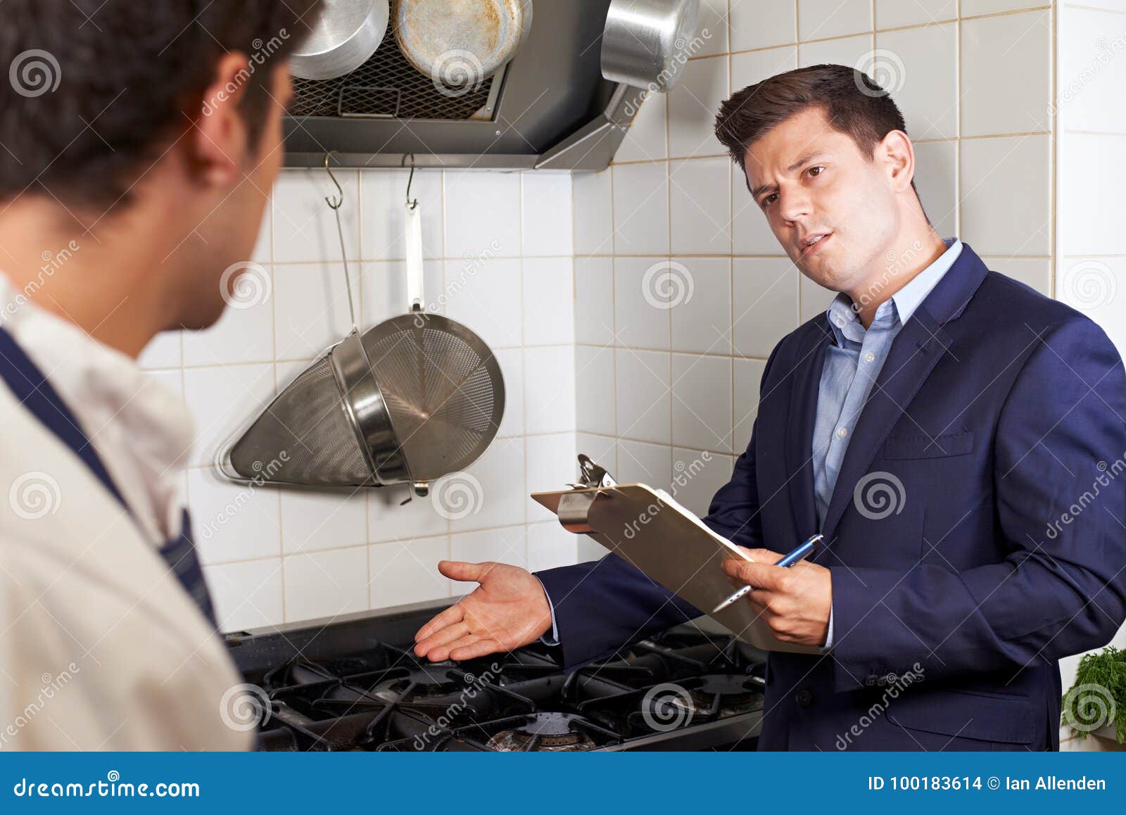 health inspector meeting with chef in restaurant kitchen