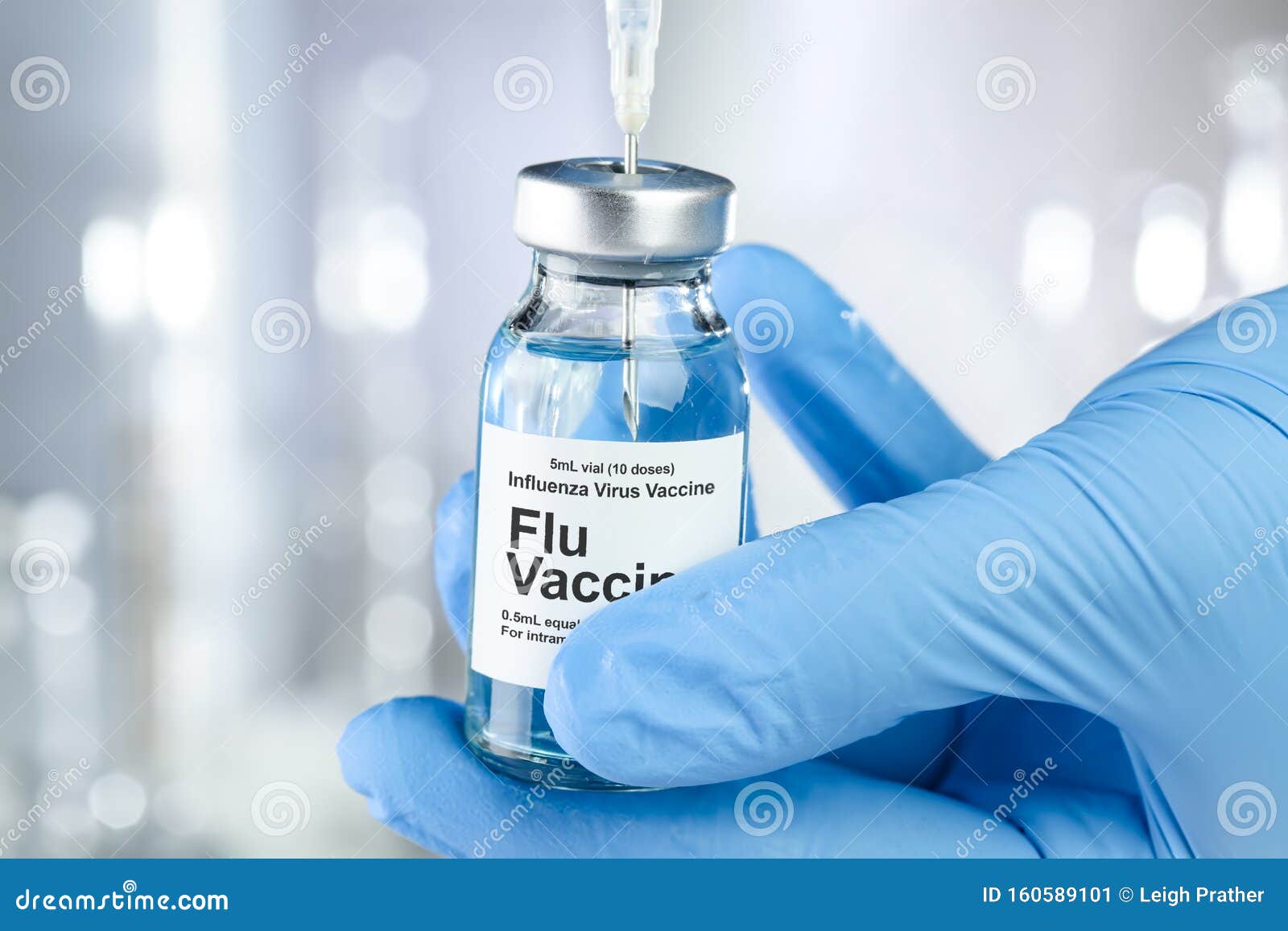 healthcare concept with a hand in medical gloves holding flu, influenza, vaccine vial