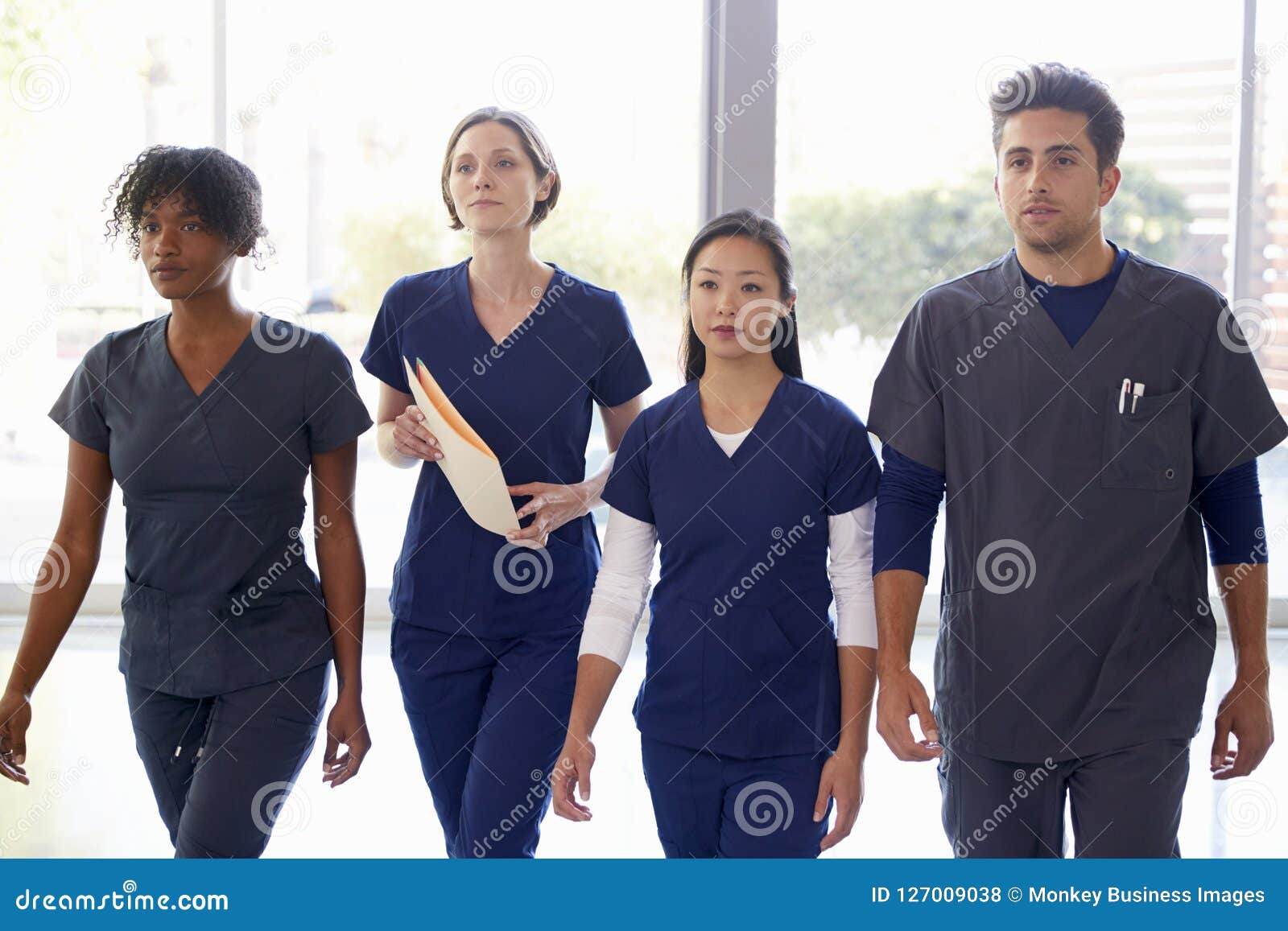 healthcare workers walk through hospital with patient notes