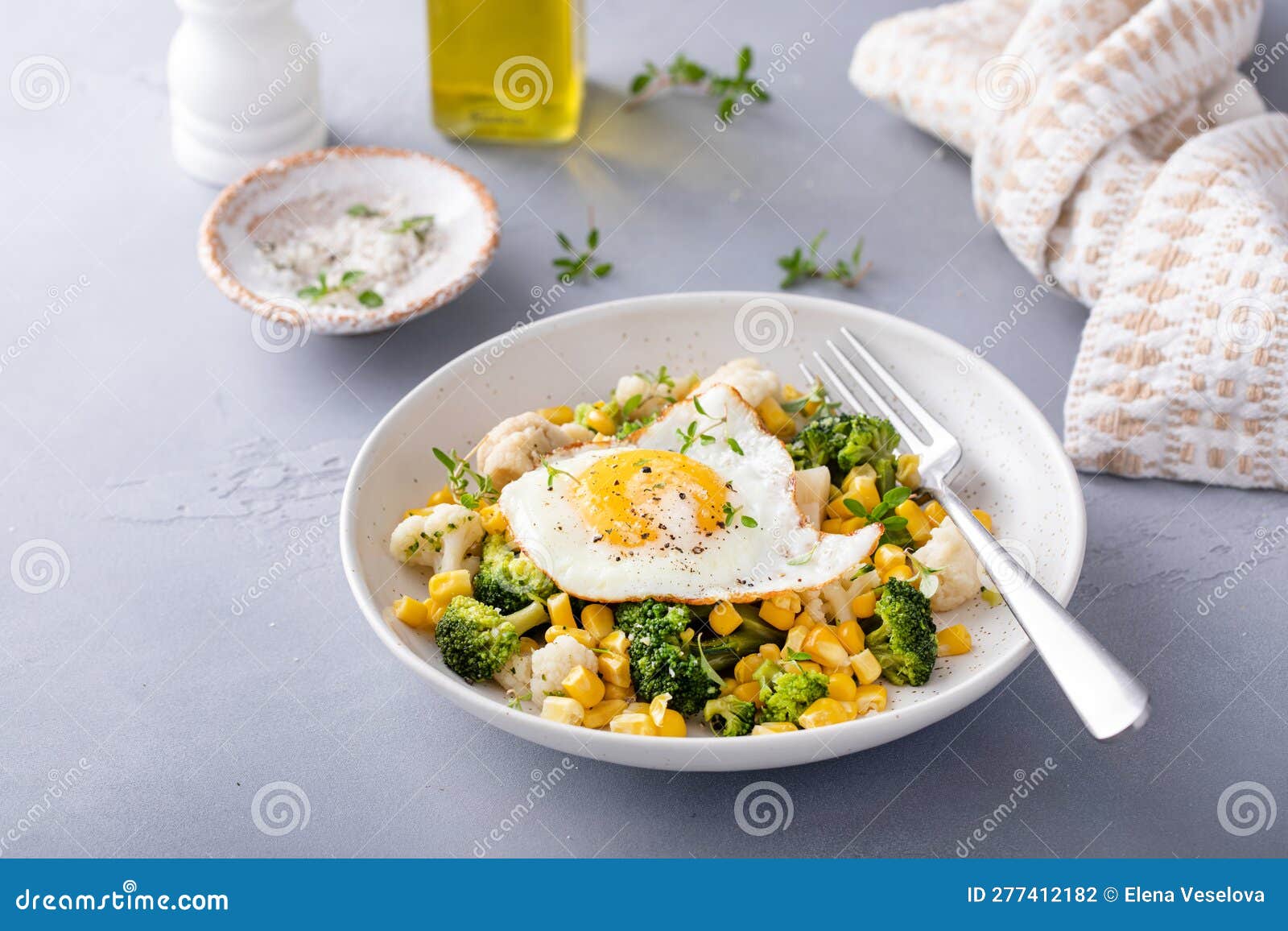 Healthy Breakfast Bowl with Cooked Vegetables and Fried Egg Stock Photo