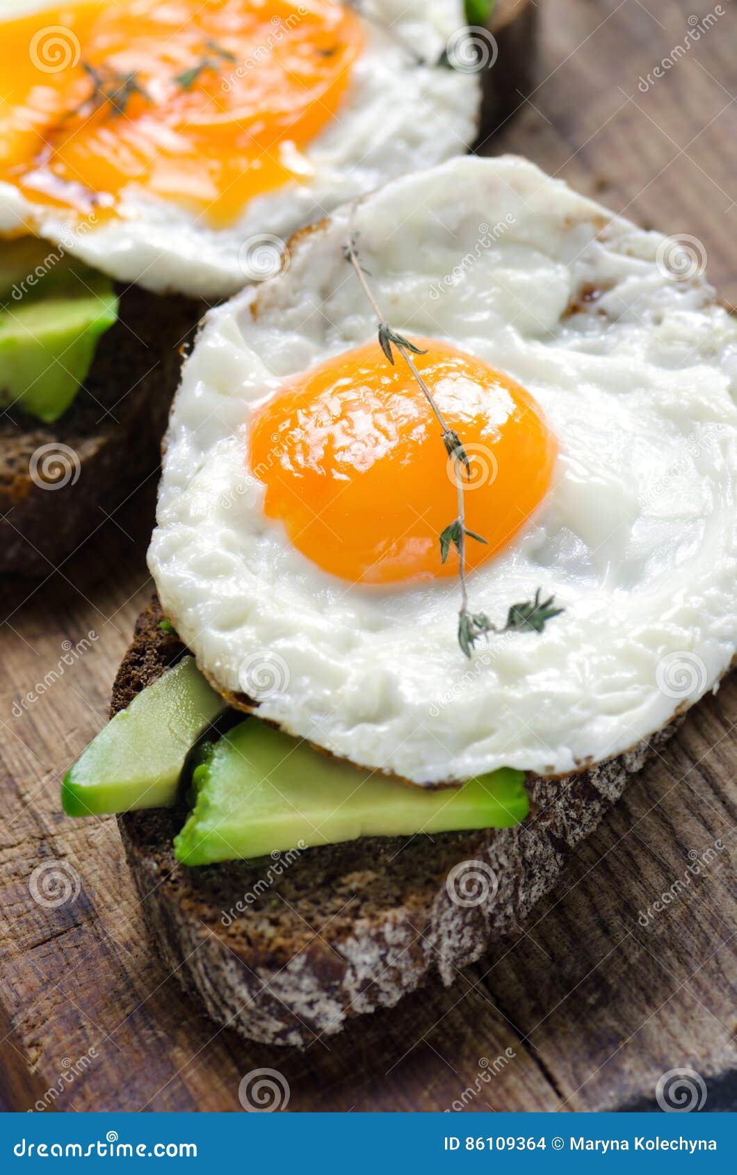 Healthy Breakfast. Sandwich with Rye Bread, Avocado and Fried Eggs