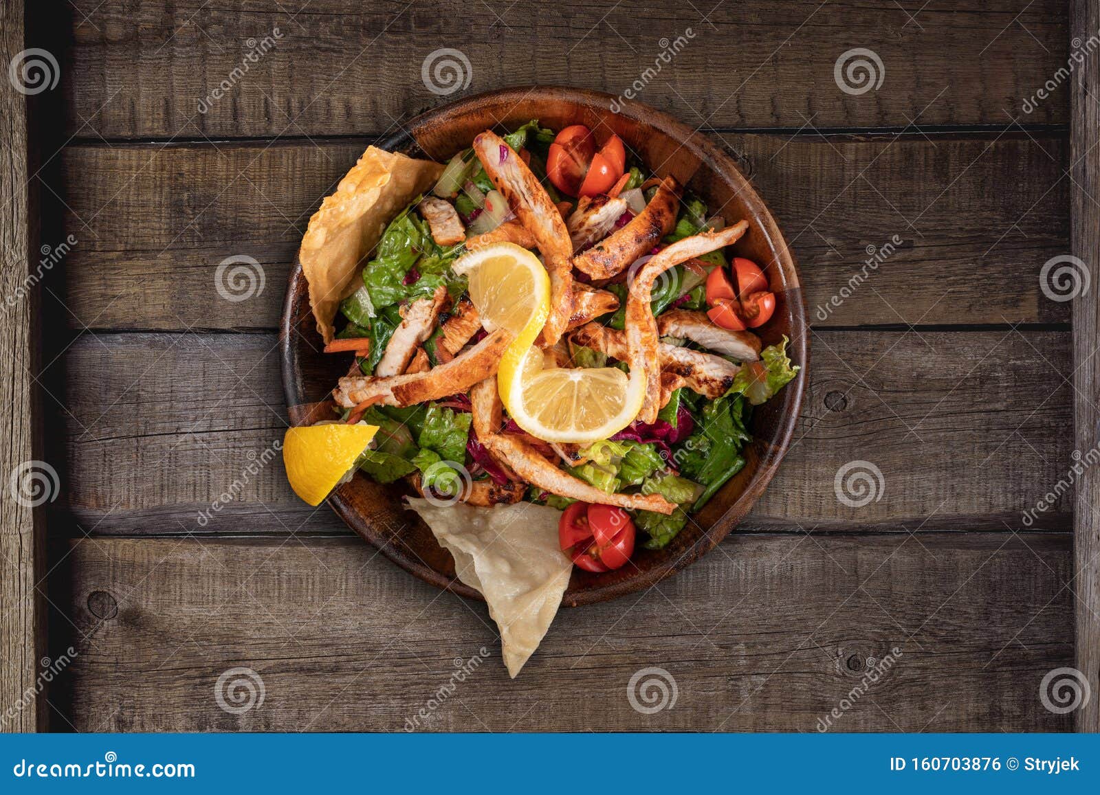 healthy chicken salad with red cabagge and tomato on rustic wooden kitchen table