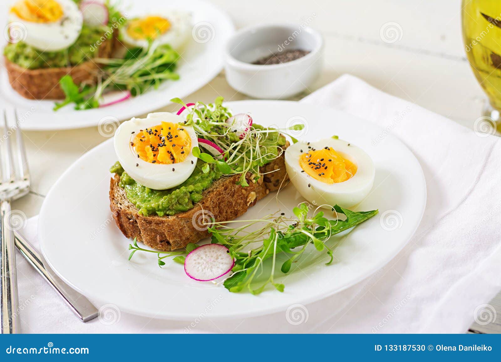Avocado Egg Sandwich with Whole Grain Bread on White Wooden Background
