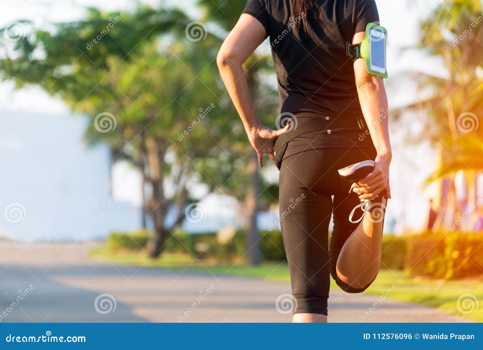 healthy life. asian fitness woman runner stretching legs before run outdoor workout in the park.