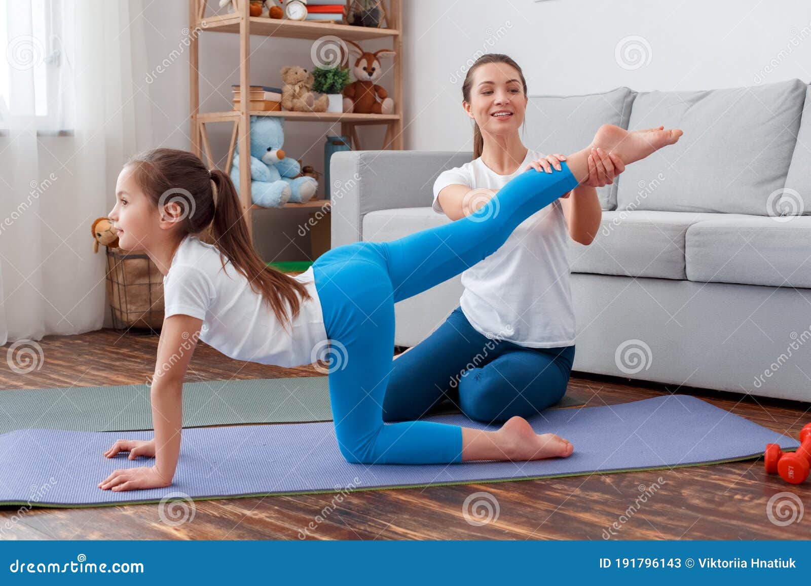 Healthy Lifestyle. Mother Assisting Daughter In Sportswear Practicing
