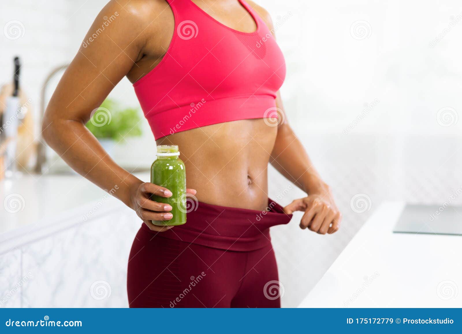 Fit Afro Girl in Oversize Pants Holding Detox Smoothie Stock Image