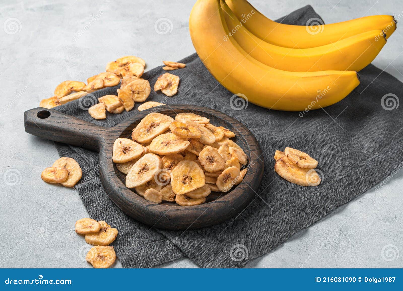 Healthy Sweets Pieces of Dried Bananas on the Background of Fresh