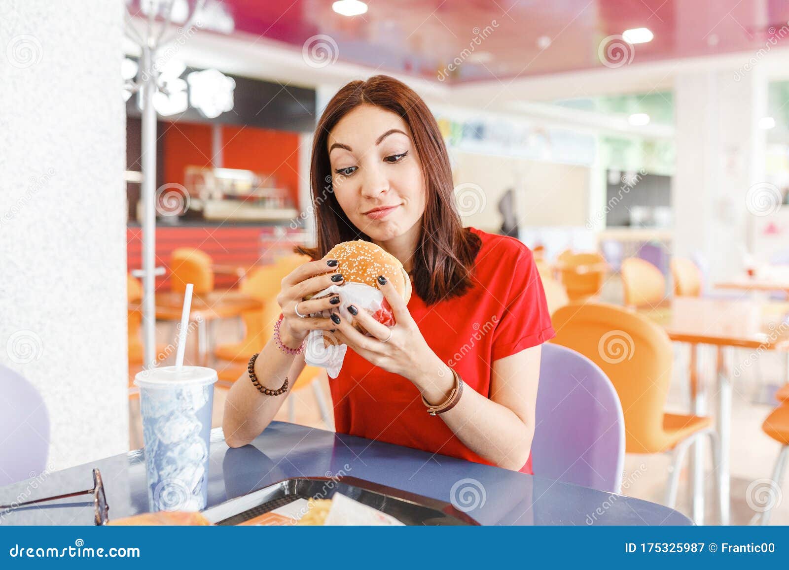 Healthy Woman Sitting In Indoors Food Court And Eating