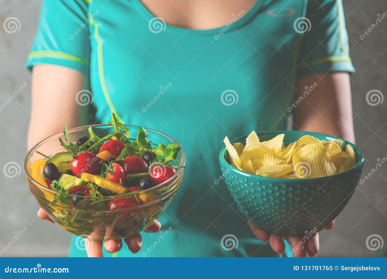 healthy young woman looking at healthy and unhealthy food, trying to make the right choice