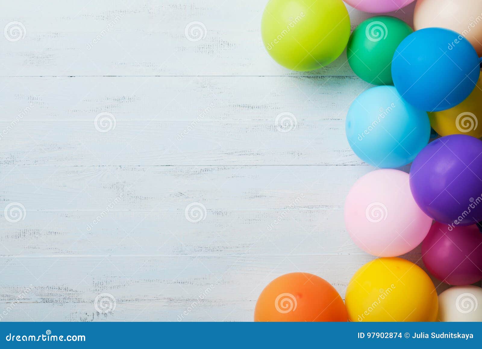 heap of colorful balloons on blue wooden table top view. birthday or party background. flat lay style. copy space for text.