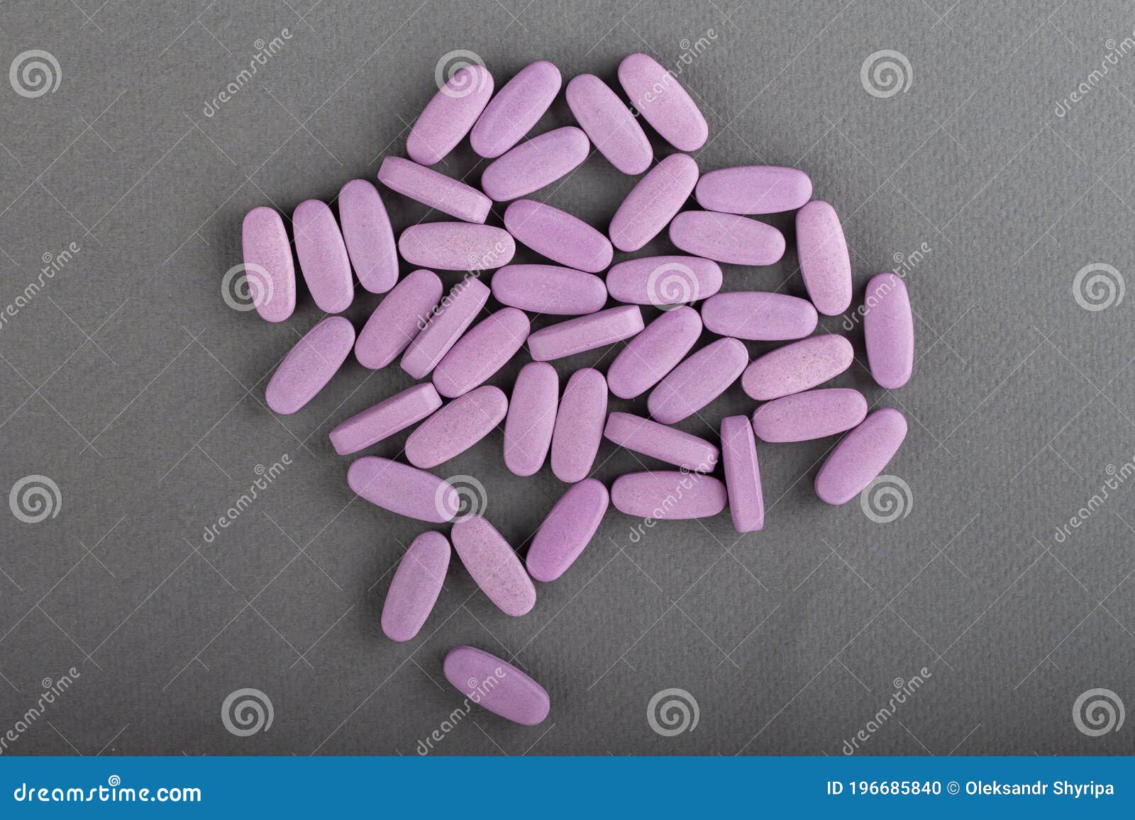 heap of pink medical pills on a gray background. health concept