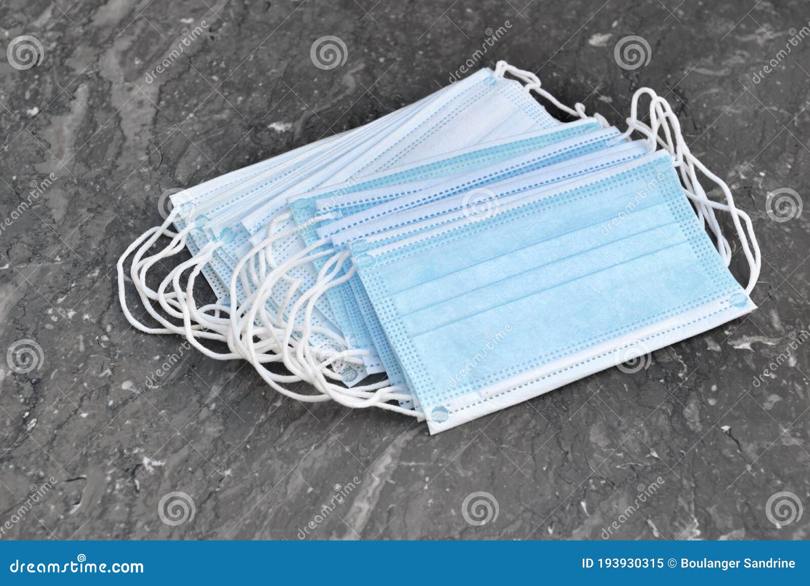 Heap of Surgical Face Mask on Grey Marble Background Stock Image