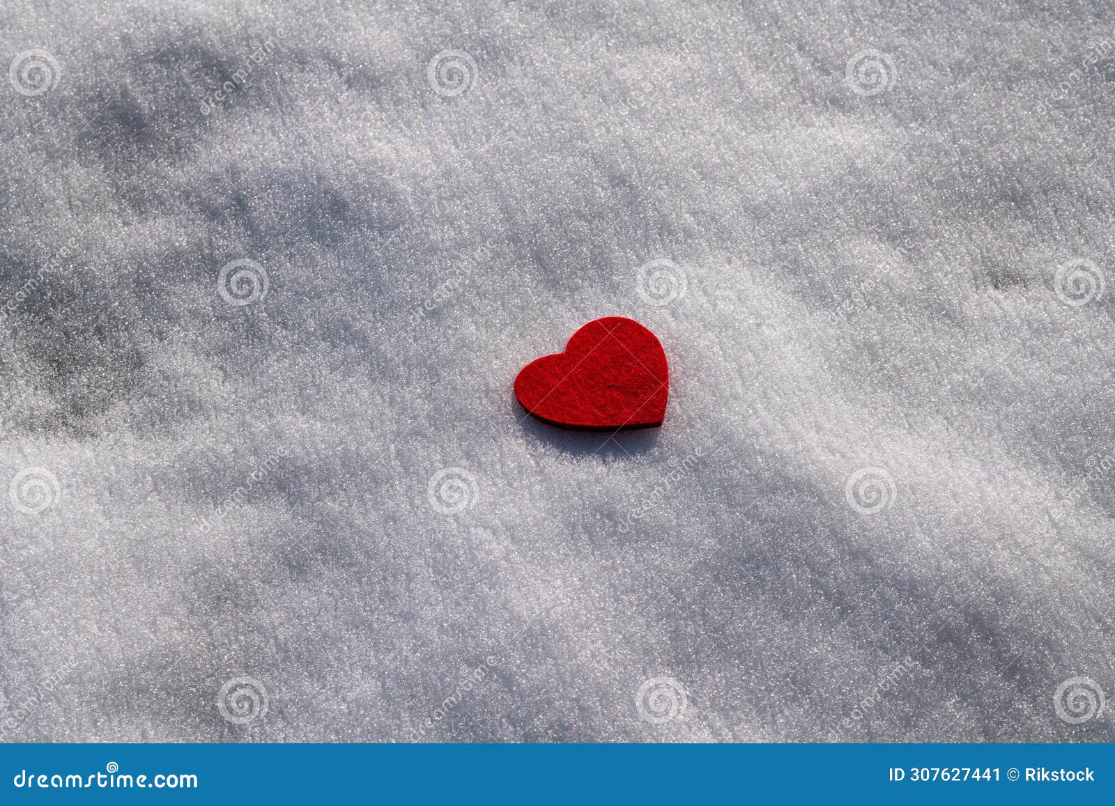 heart of fabric in the pure white snow. in february, in the mountains with snow, you can celebrate the valentine's day