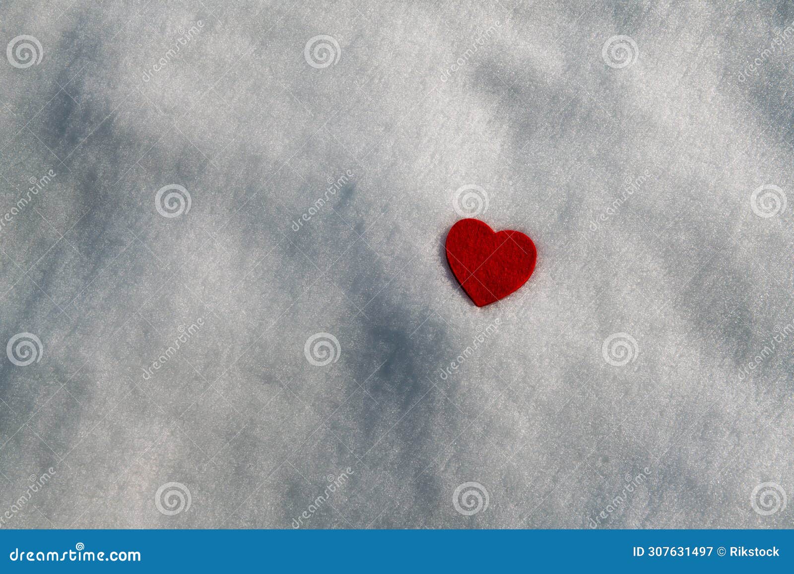 heart of fabric in the pure white snow. in february, in the mountains with snow, you can celebrate the valentine's day