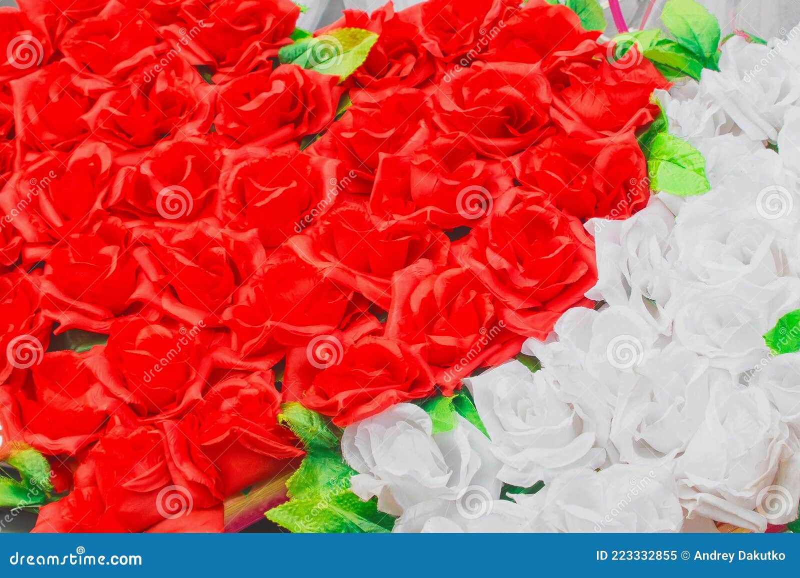 heart of red artificial roses opposite white inanimate background flowers