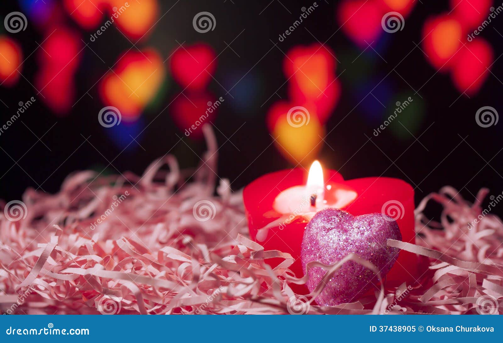 Close-up shot of three beautiful colourful heart-shaped candles with  glitter. Stock Photo by wirestock