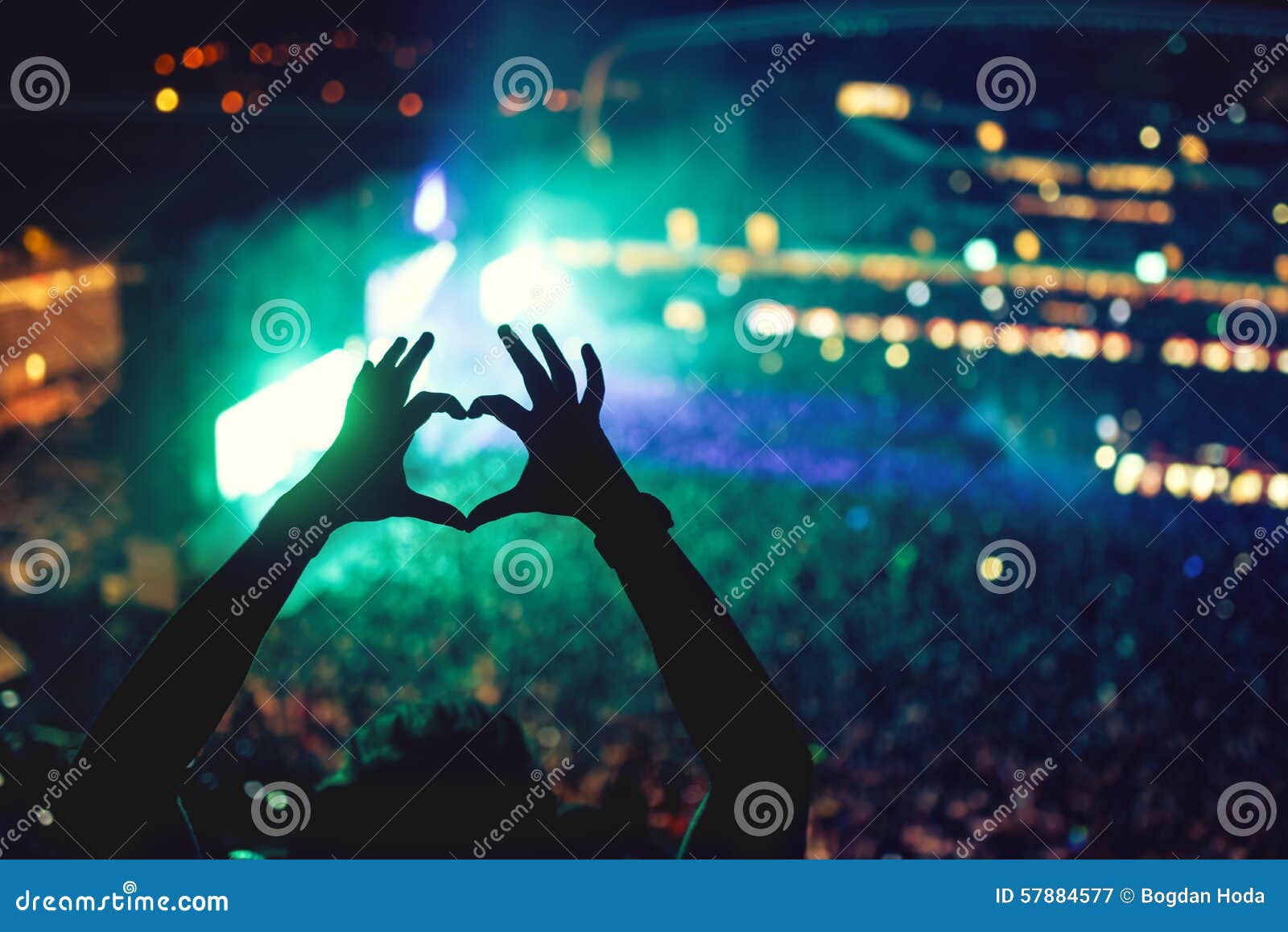 heart d hands at concert, loving the artist and the festival. music concert with lights and silhouette of a man enjoying