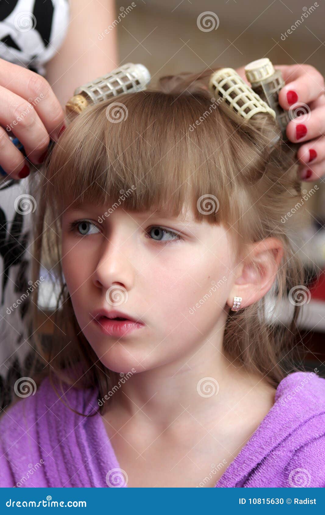 A mother curls daughter s hairs by heat retro rollers