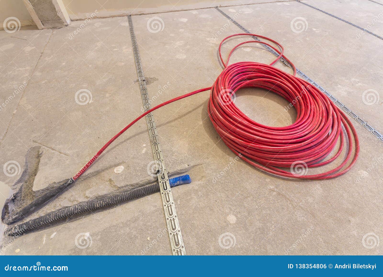 Heating Red Electrical Cable Wire Roll on Cement Floor Copy Space Background. Renovation and