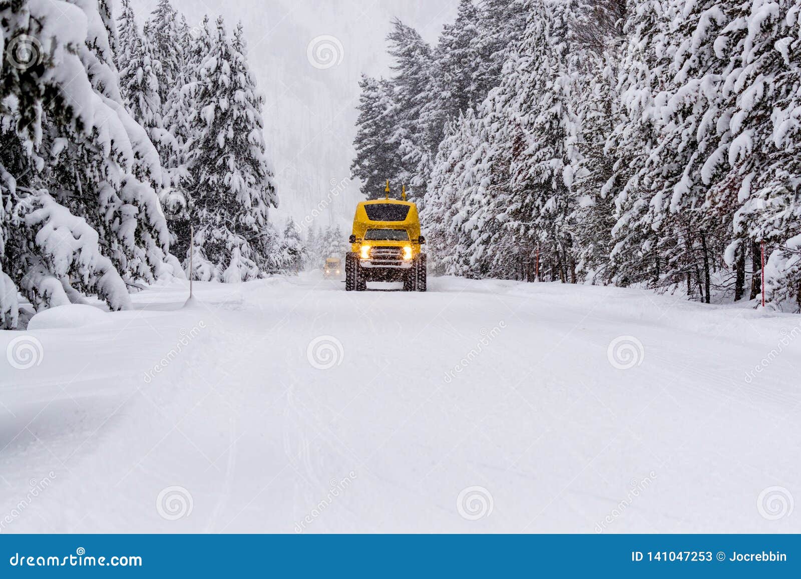 heavy duty snow bus vehicle plows over snow of highway 20 in yellowstone in winter