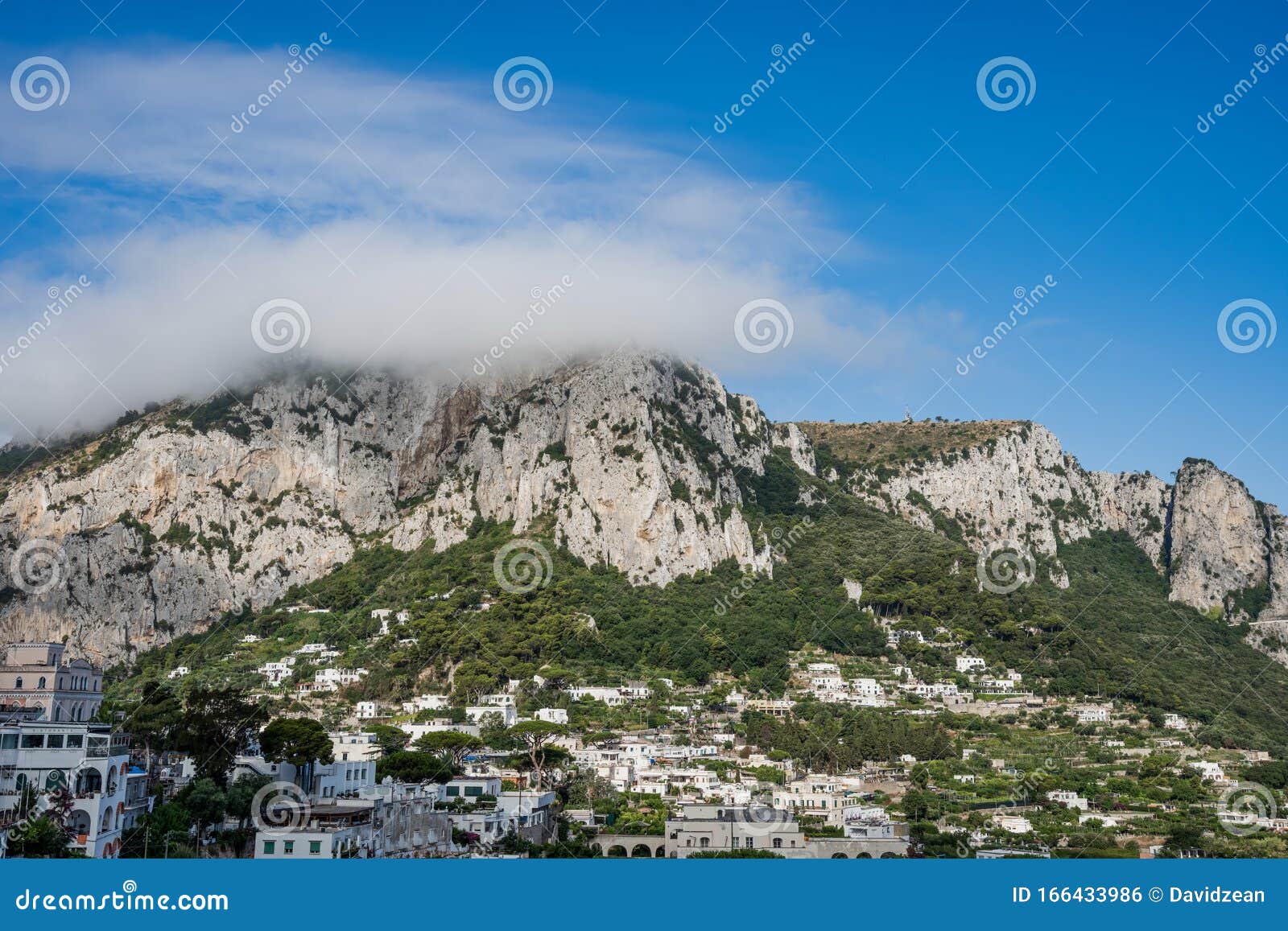 heavy fog on monte solare on capri island in summer time with villages on the mountain