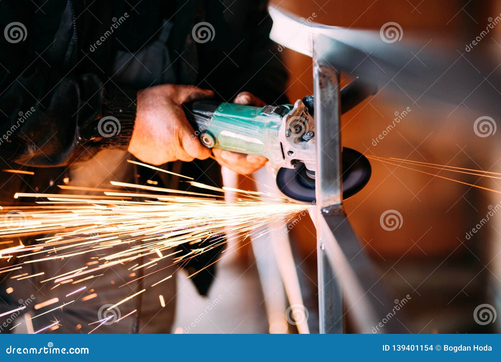 heavy industry worker cutting steel with angle grinder on construction site