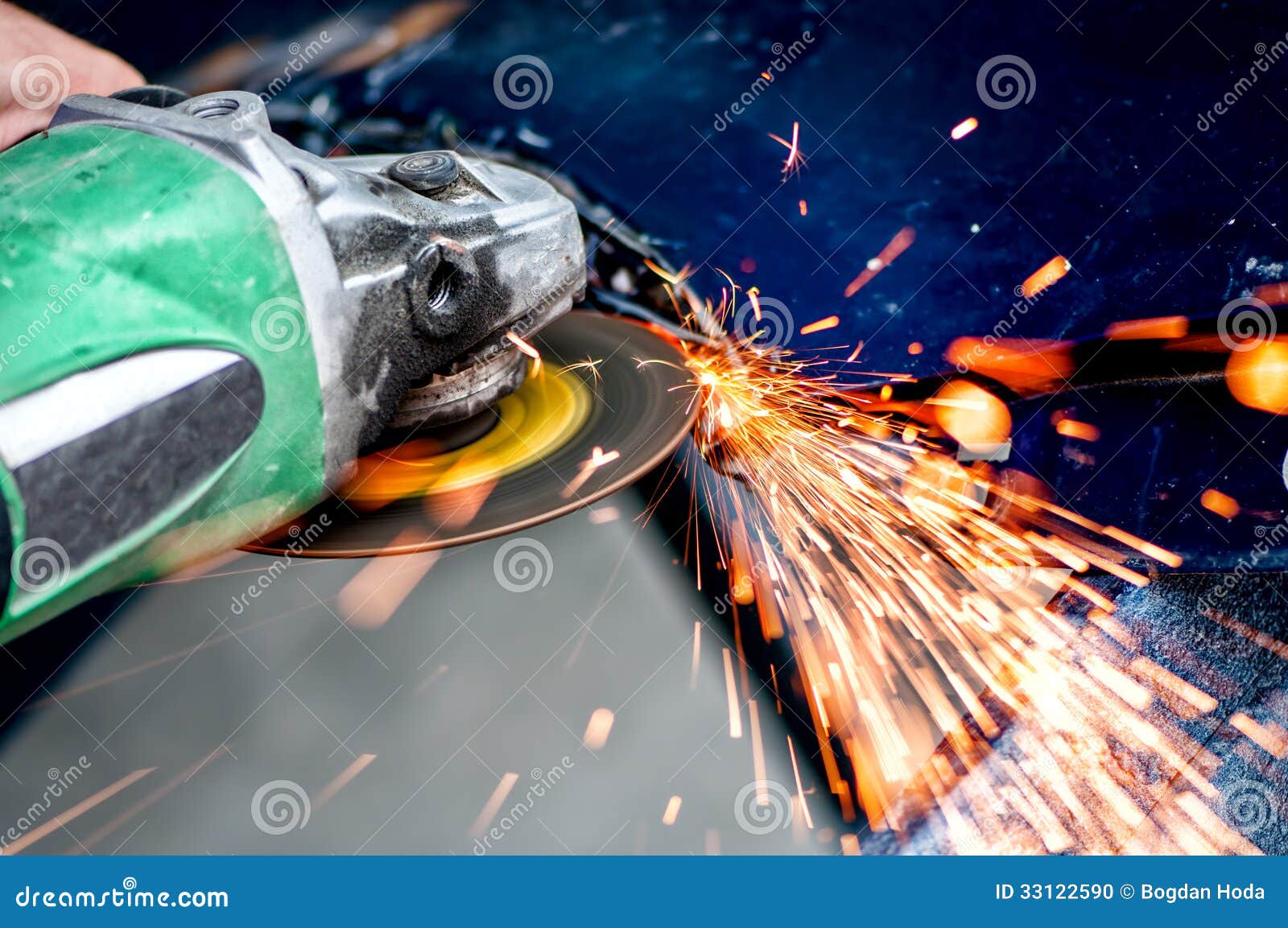heavy industry worker cutting steel with angle grinder