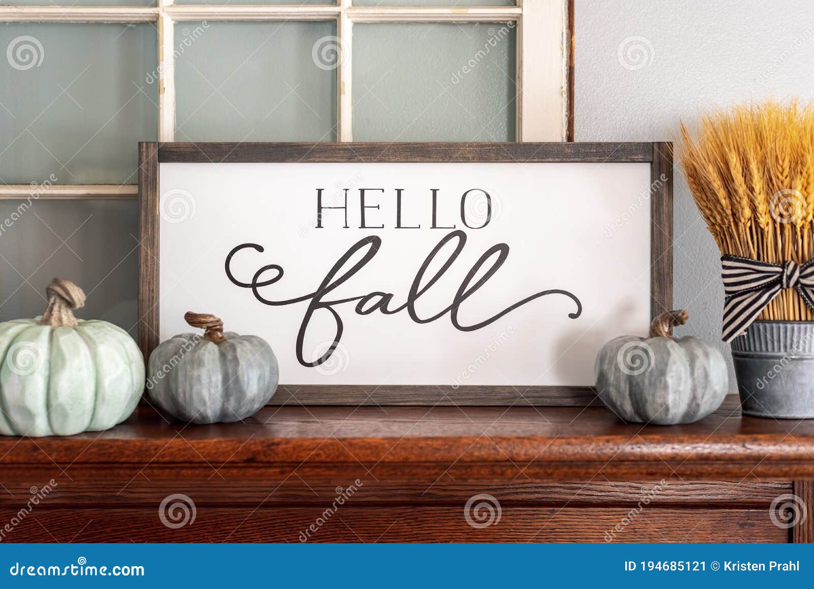 hello fall sign and neutral colored pumpkins on wood mantel