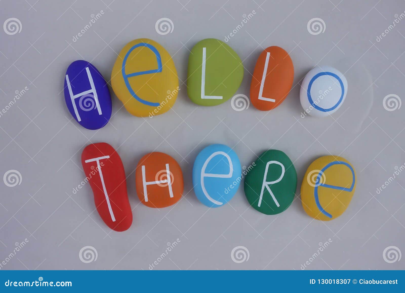 Hello There Text with a Composition of Colored Stones Over White Sand