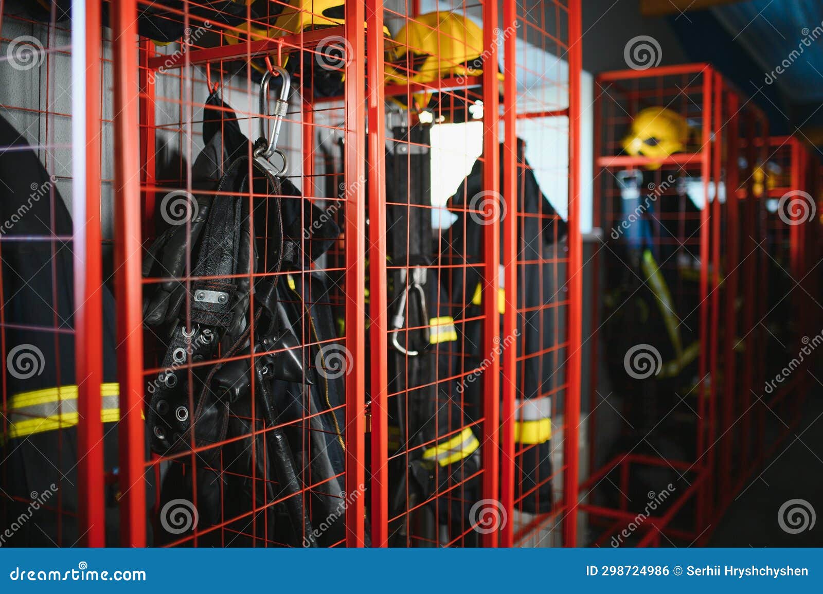 Helmets and Uniforms in Locker Room of Fire Fighters Stock Photo