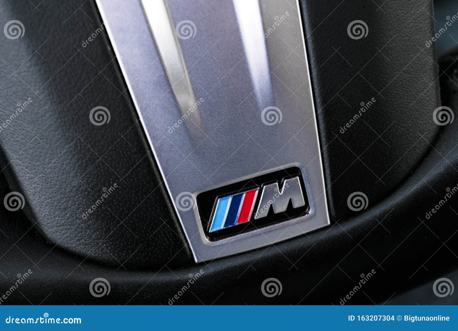Close Up View of a BMW M Logo on Black Leather Steering Wheel
