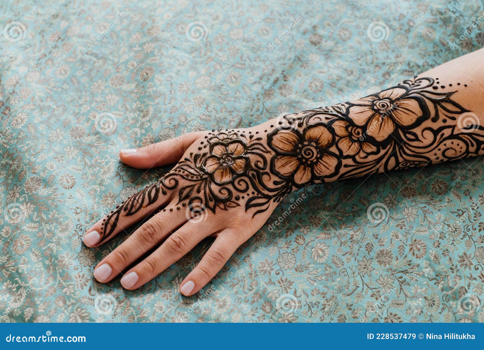 Artista aplicando tatuagem de henna mehndi na mão feminina