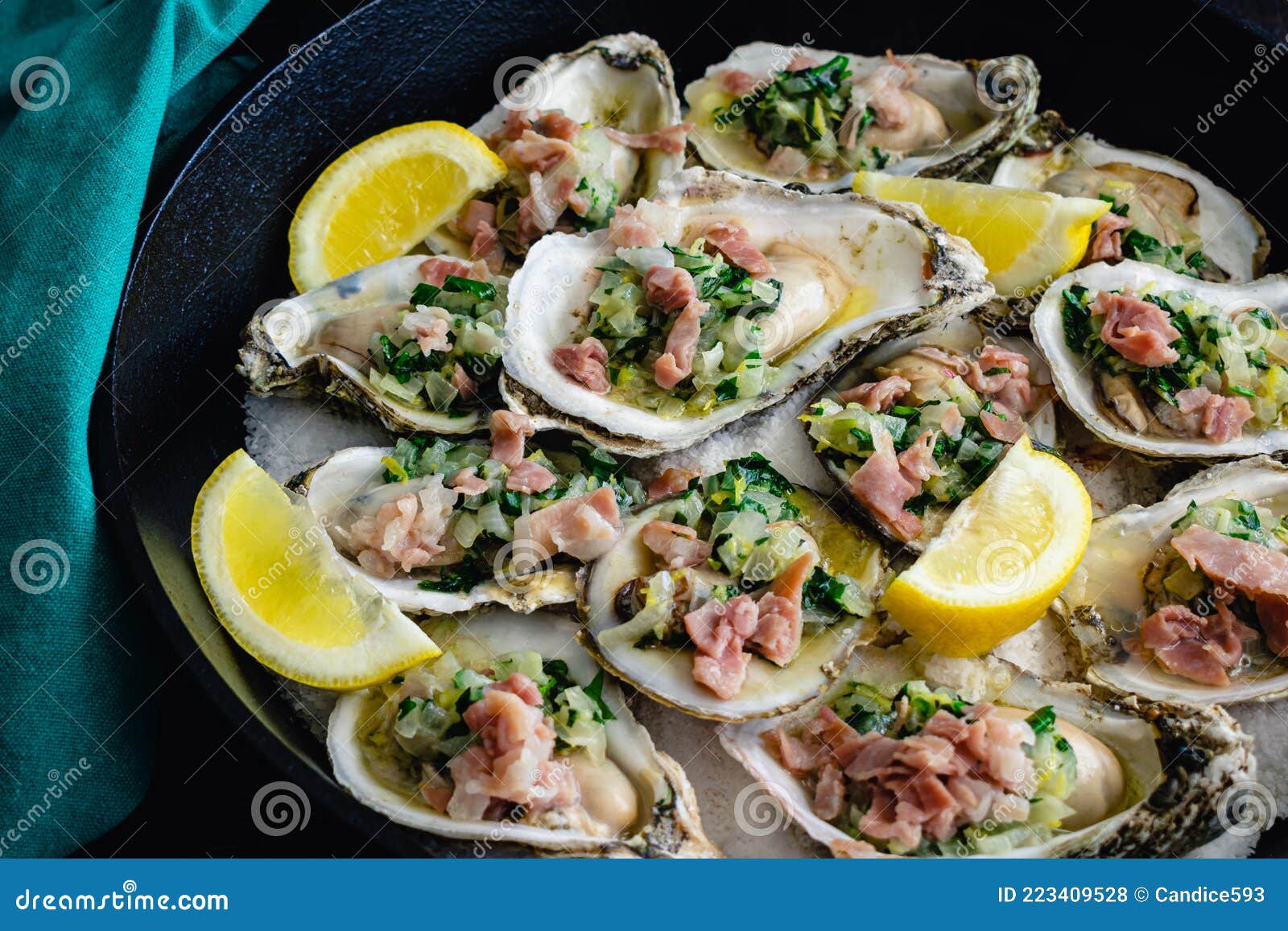 Herb Butter Oysters with Prosciutto in a CastIron Skillet Stock Photo