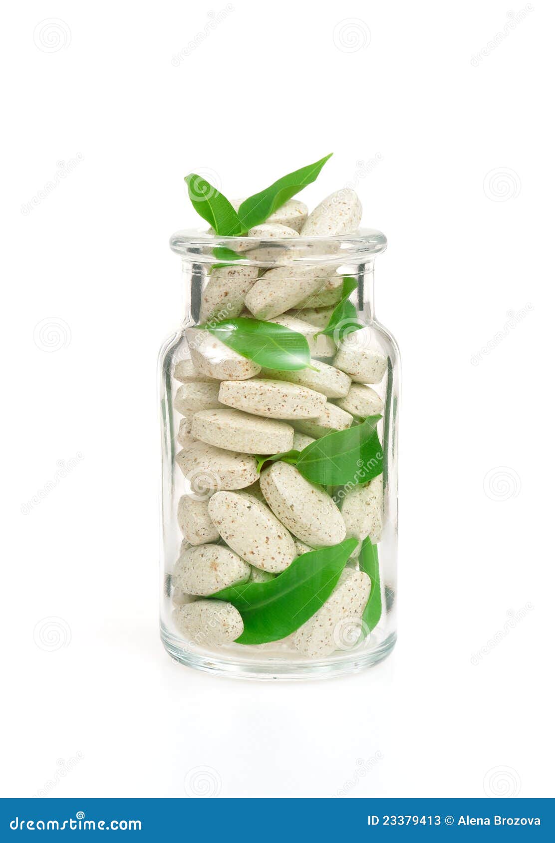 herbal supplement pills and fresh leaves in glass