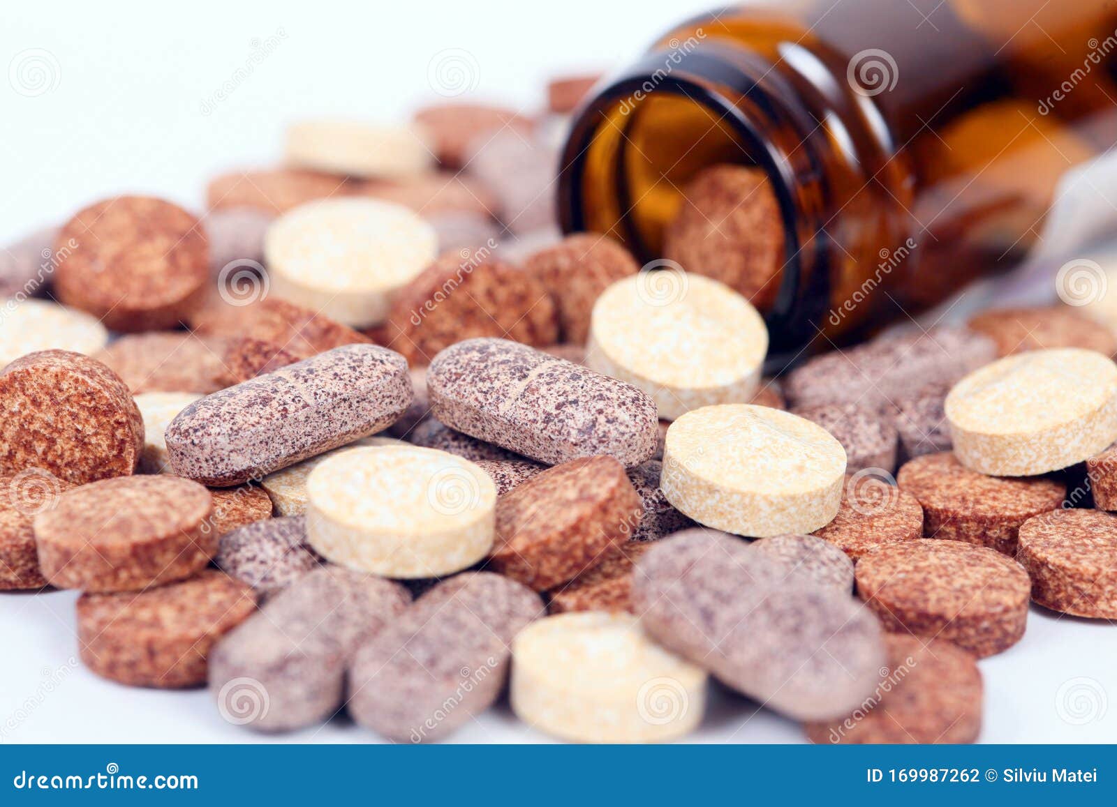 closeup of herbal vitamin and supplement pills with herbs.