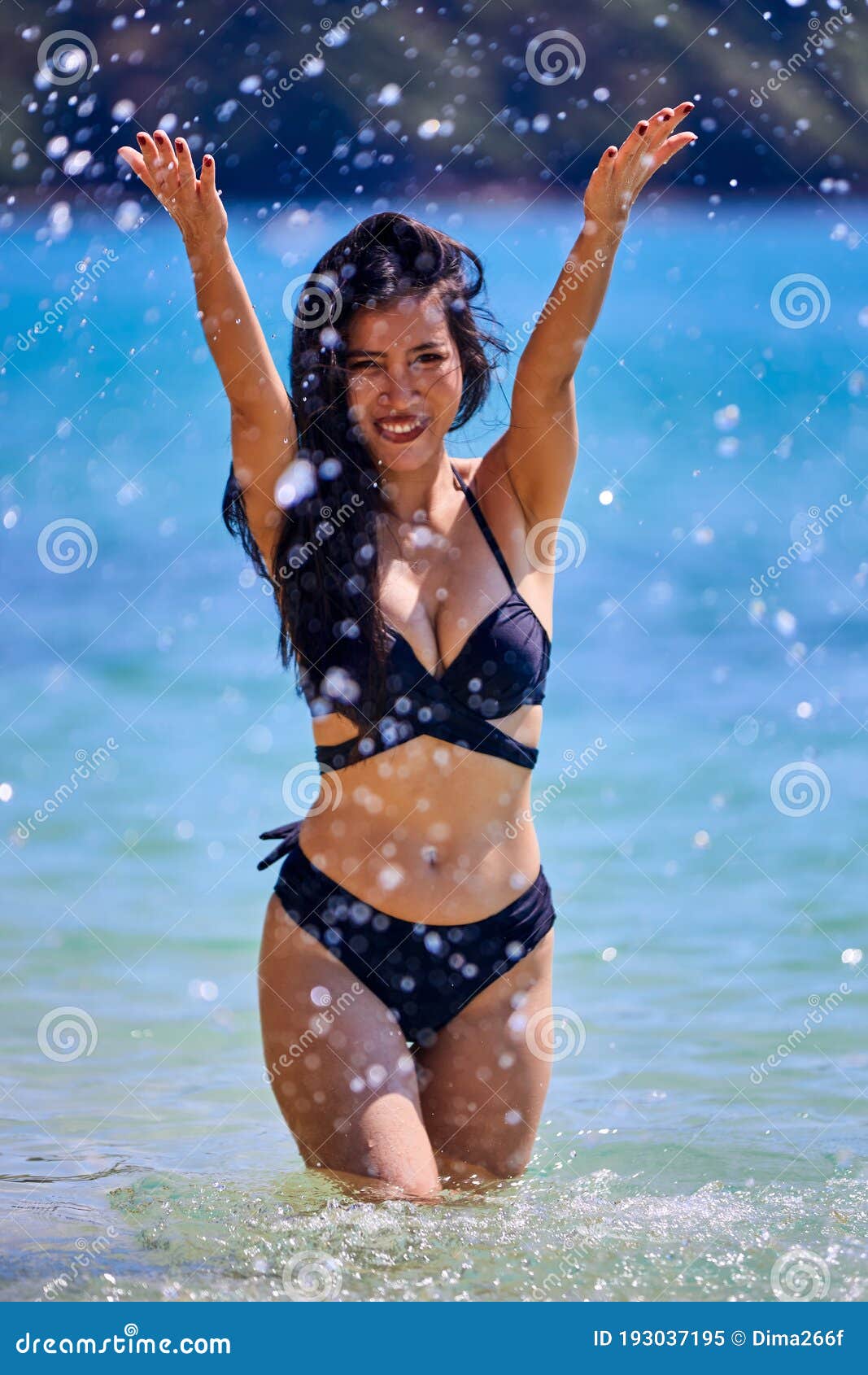 Hermosa Mujer Asi Tica Jugando Con Salpicaduras De Agua En Una Playa Tropical Imagen De Archivo