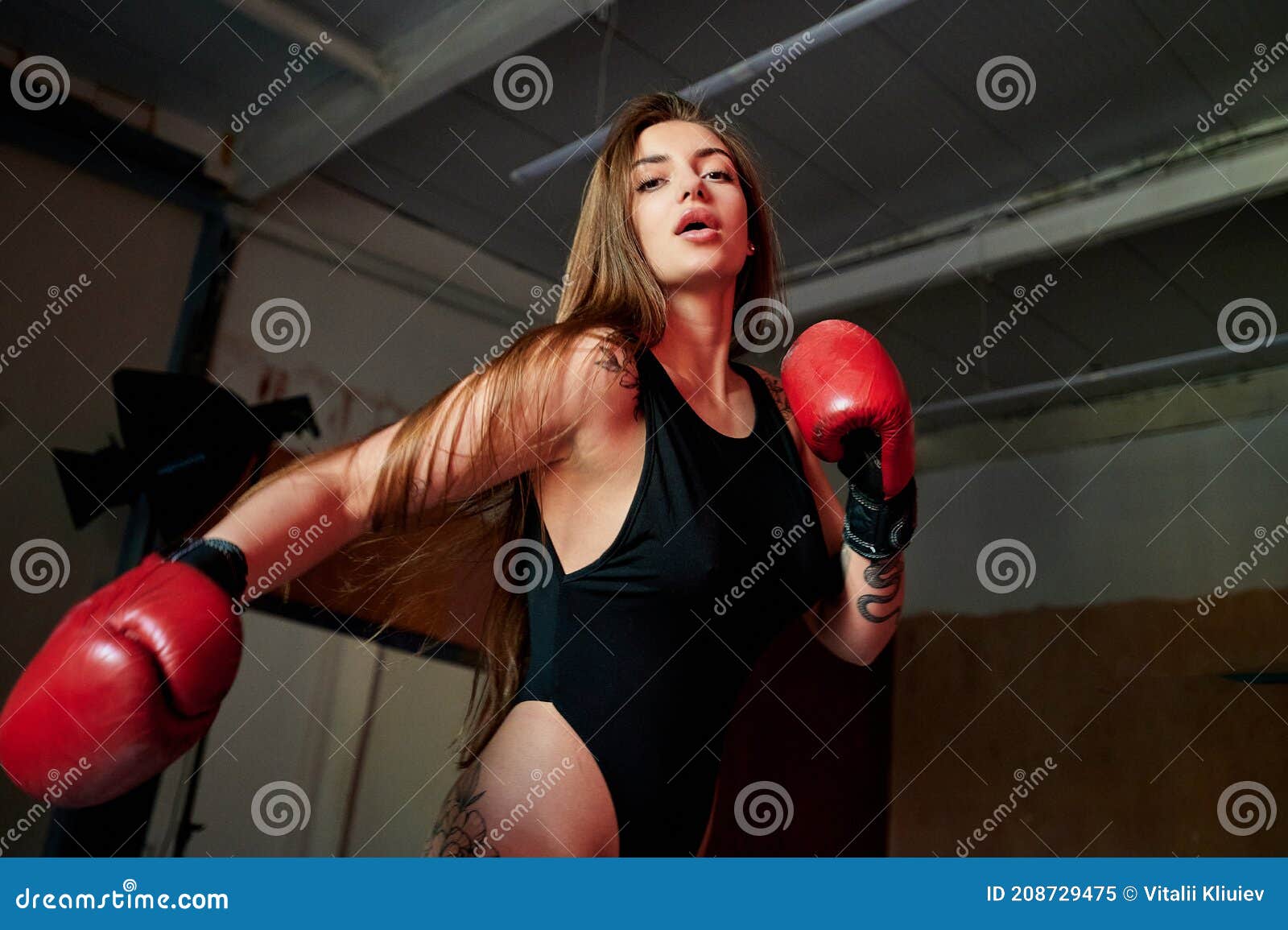 Mujer fitness con guantes de boxeo rojos.