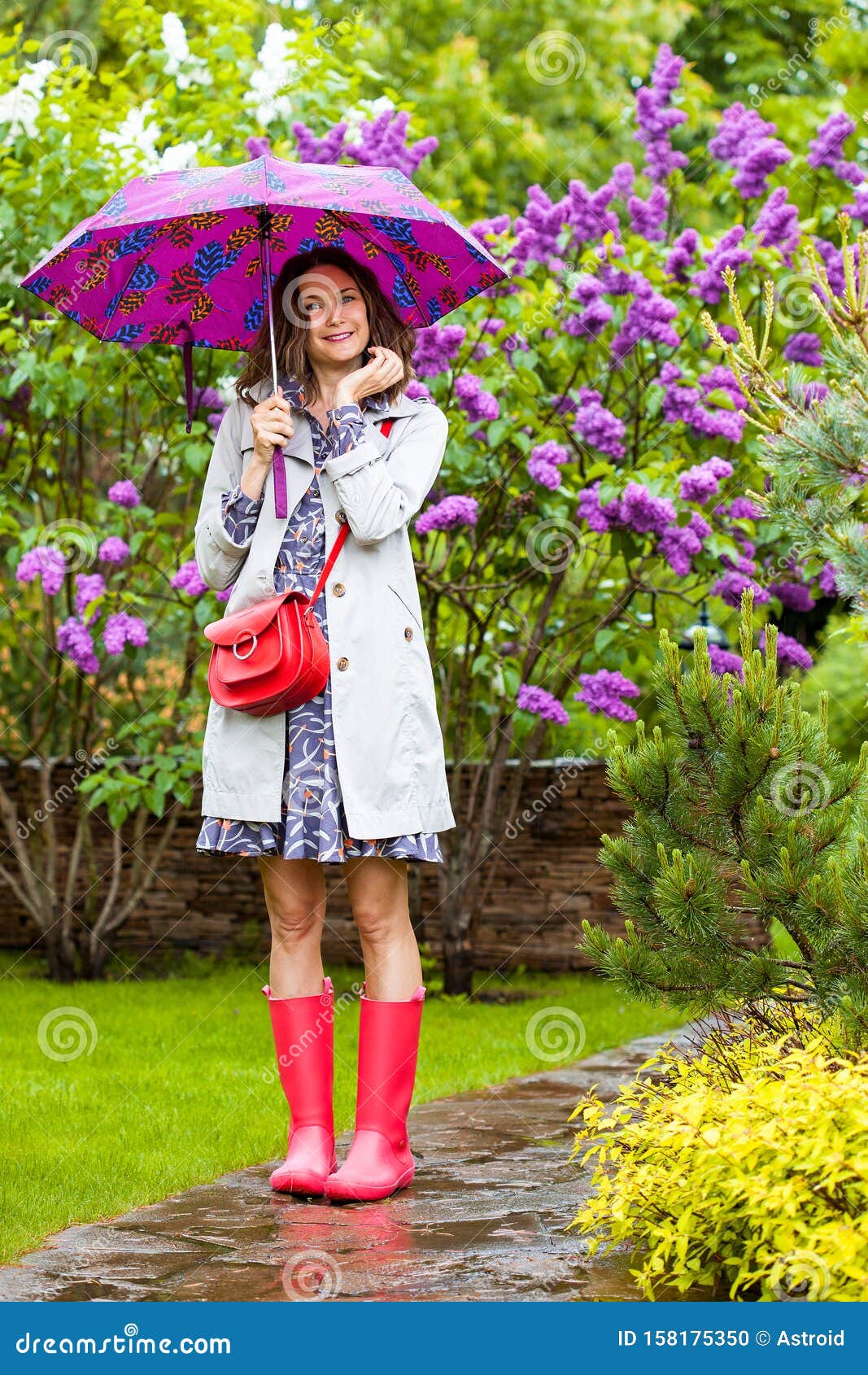 Mujer Que Lleva La Capa Impermeable Debajo Del Paraguas Imagen de