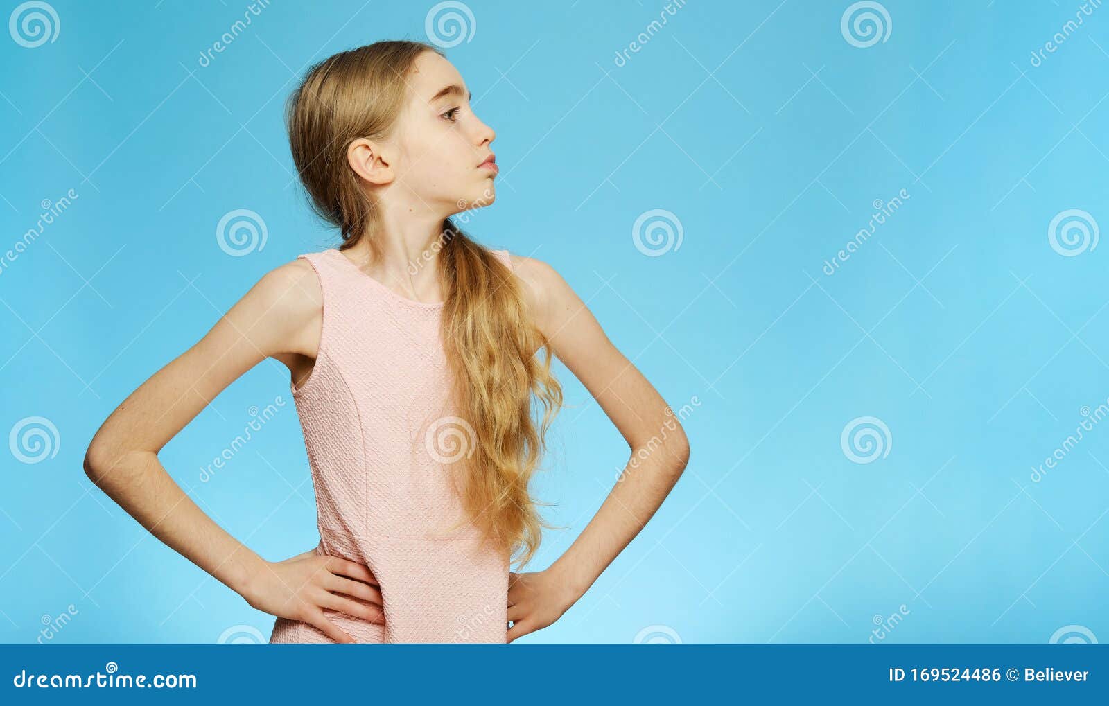 Hermosa Niña Pequeña Toma La Mano En La Cintura, Pequeña Chica Se Pone De  Perfil Retrato Aislado Sobre Fondo Azul Foto de archivo - Imagen de hembra,  blanco: 169524486