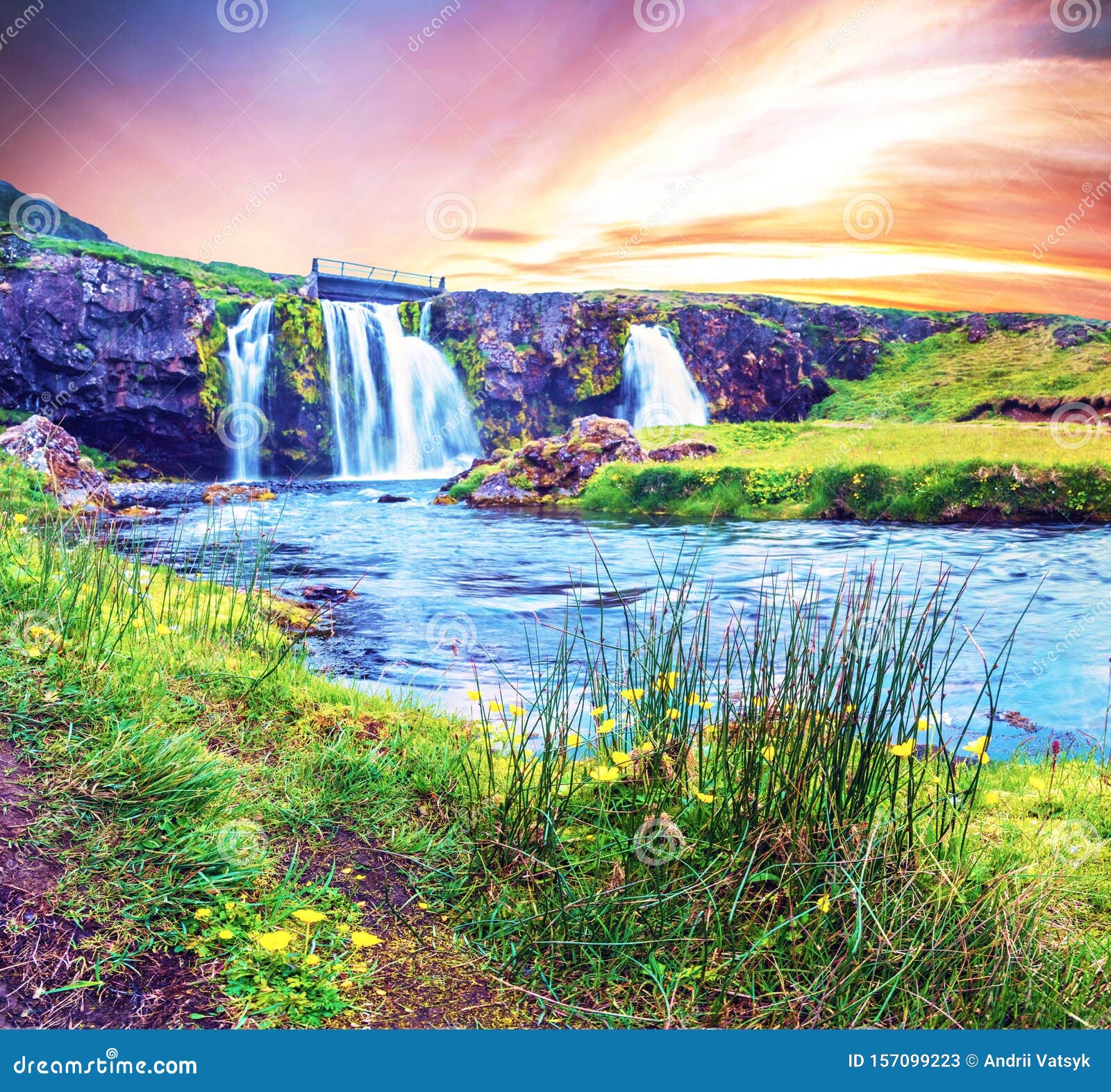 Hermoso Paisaje Natural MÃ¡gico Con Una Cascada De Kirkjudown Y Flores  Amarillas Amanecer En Islandia. PaÃses ExÃ³ticos. IncreÃb Imagen de archivo  - Imagen de aerosol, azul: 157099223