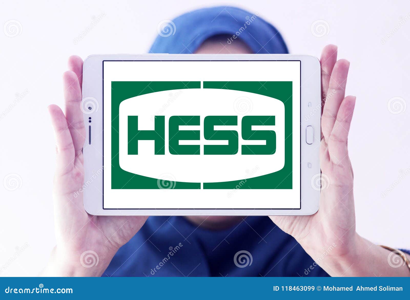 Hess Corporation logo. Logo of Hess Corporation on samsung tablet holded by arab muslim woman. Hess is an American global independent energy company engaged in the exploration and production of crude oil and natural gas