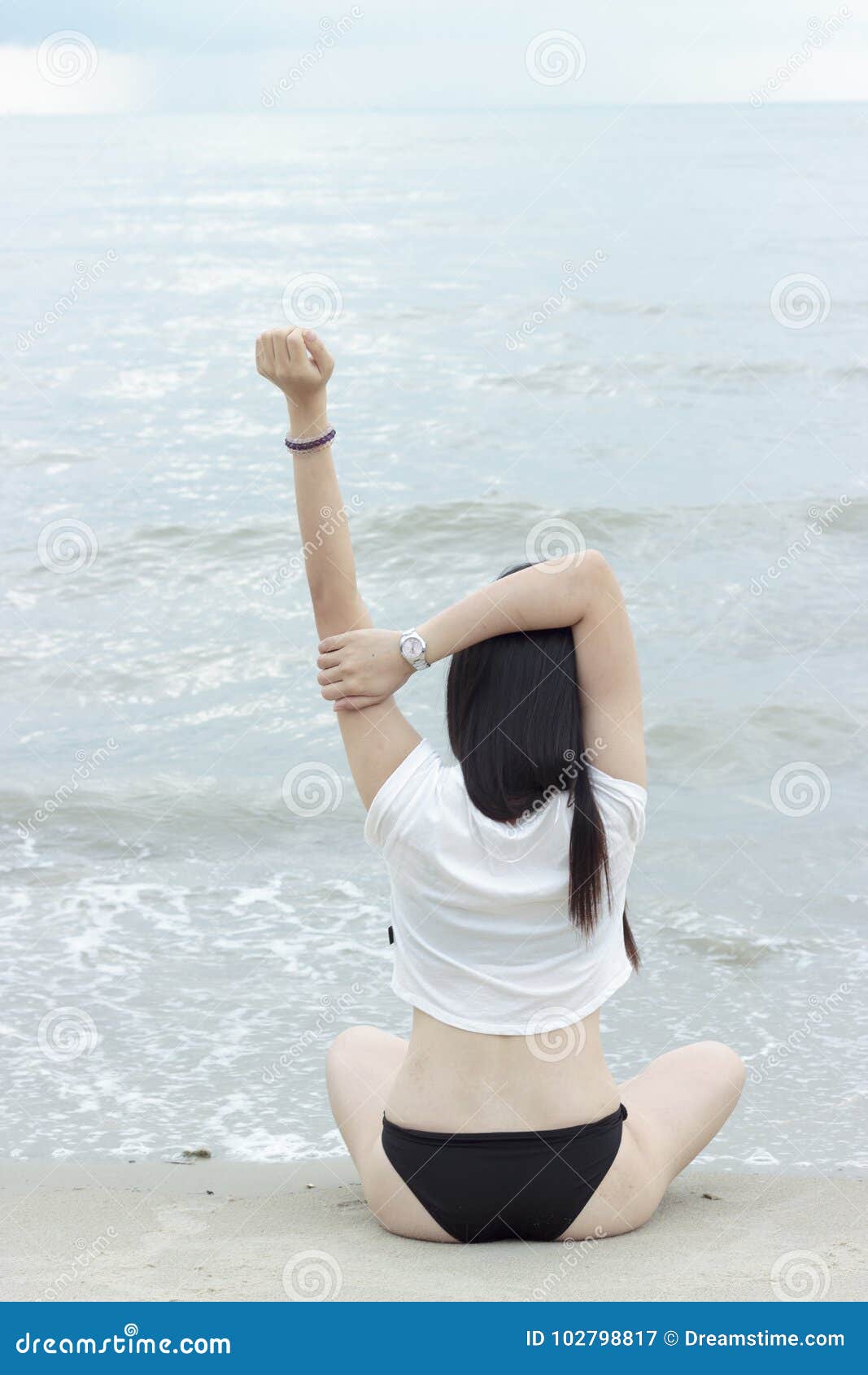 Het Aziatische Bikinimodel stelt bij strand. Het Aziatische Bikinimodel stelt een yoga bij het strand